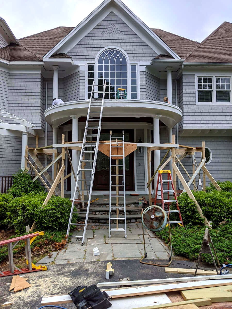 Front entry portico with custom round columns and arched balcony being built, Connecticut carpentry project