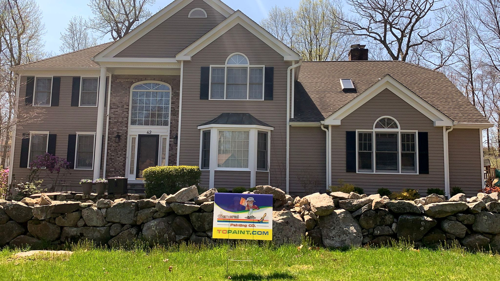Beige colonial home with stone wall in Connecticut